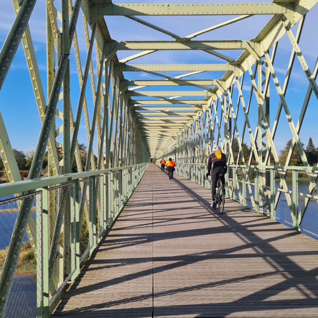 Ancien pont de chemin de fer réhabilité en pont de passage pour les vélos et piétons. Pont en fer vert avec des cycliste passant reliant Sully sur Loire à Saint père sur Loire