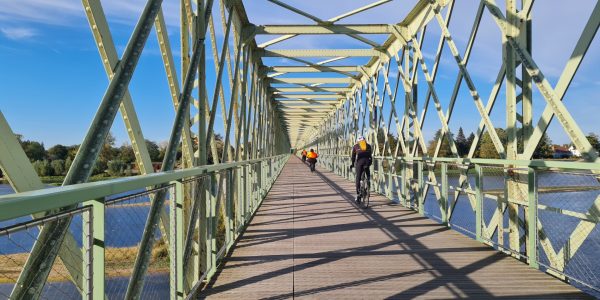 Ancien pont de chemin de fer réhabilité en pont de passage pour les vélos et piétons. Pont en fer vert avec des cycliste passant reliant Sully sur Loire à Saint père sur Loire